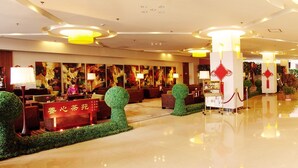 A spacious lobby with a polished floor, red and gold decor, and a reception desk. - Elegance Hotel Tianjin (Tianjin)