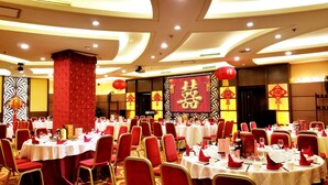 A banquet hall with round tables set for a formal event, featuring red chairs and white tablecloths. - Elegance Hotel Tianjin (Tianjin)