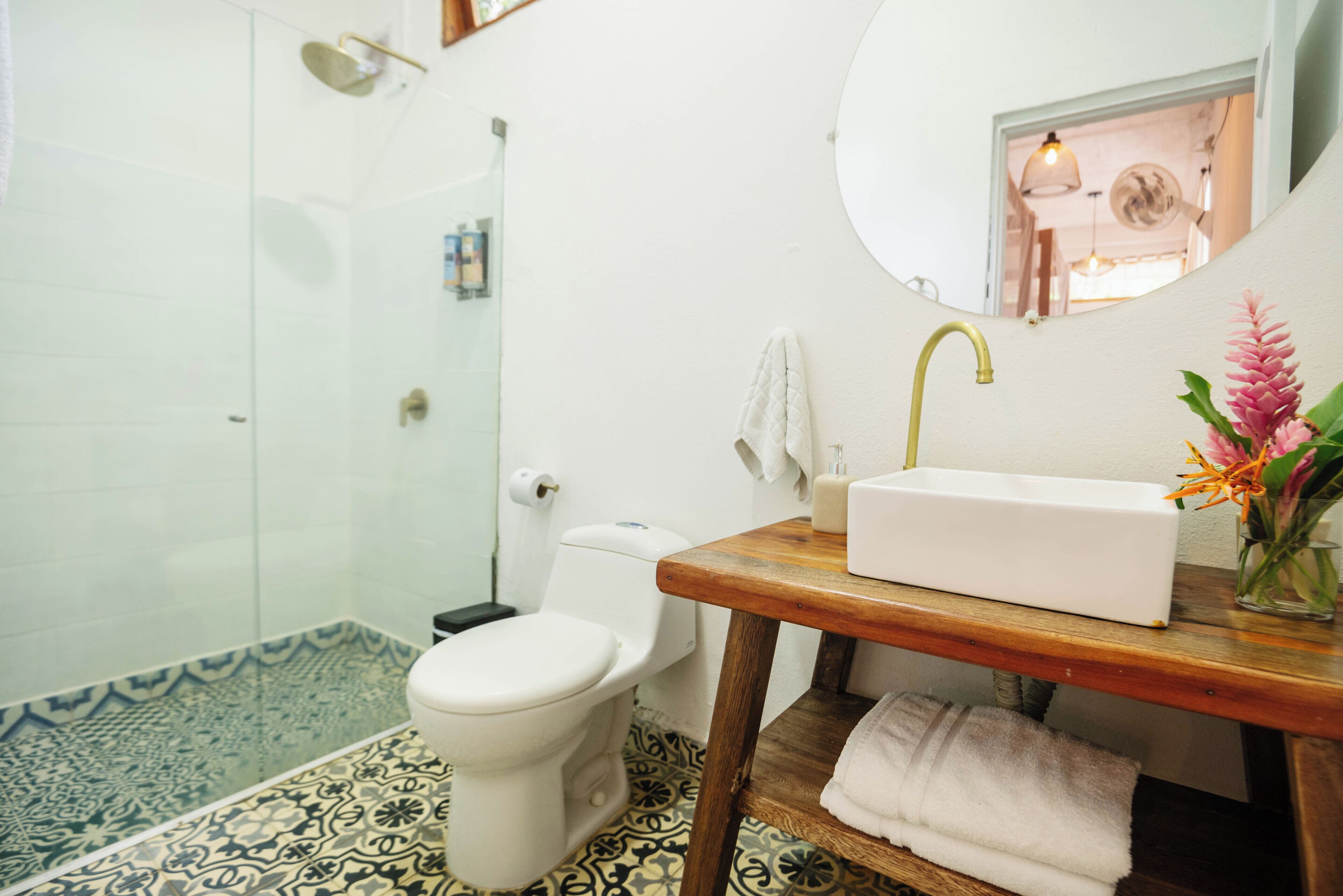 A bathroom with a toilet, sink, and shower.