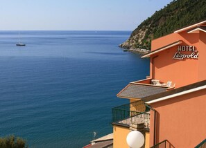 A coastal hotel named 'Hotel Leopold' with a view of the sea and a sailboat in the distance. - Hotel Leopold (Moneglia)