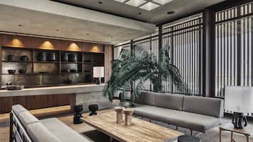 En moderne stue med sofa, sofabord og en stor plante.