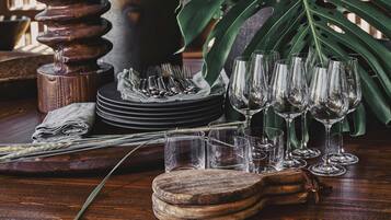 A wooden table with glassware, plates, and a napkin.