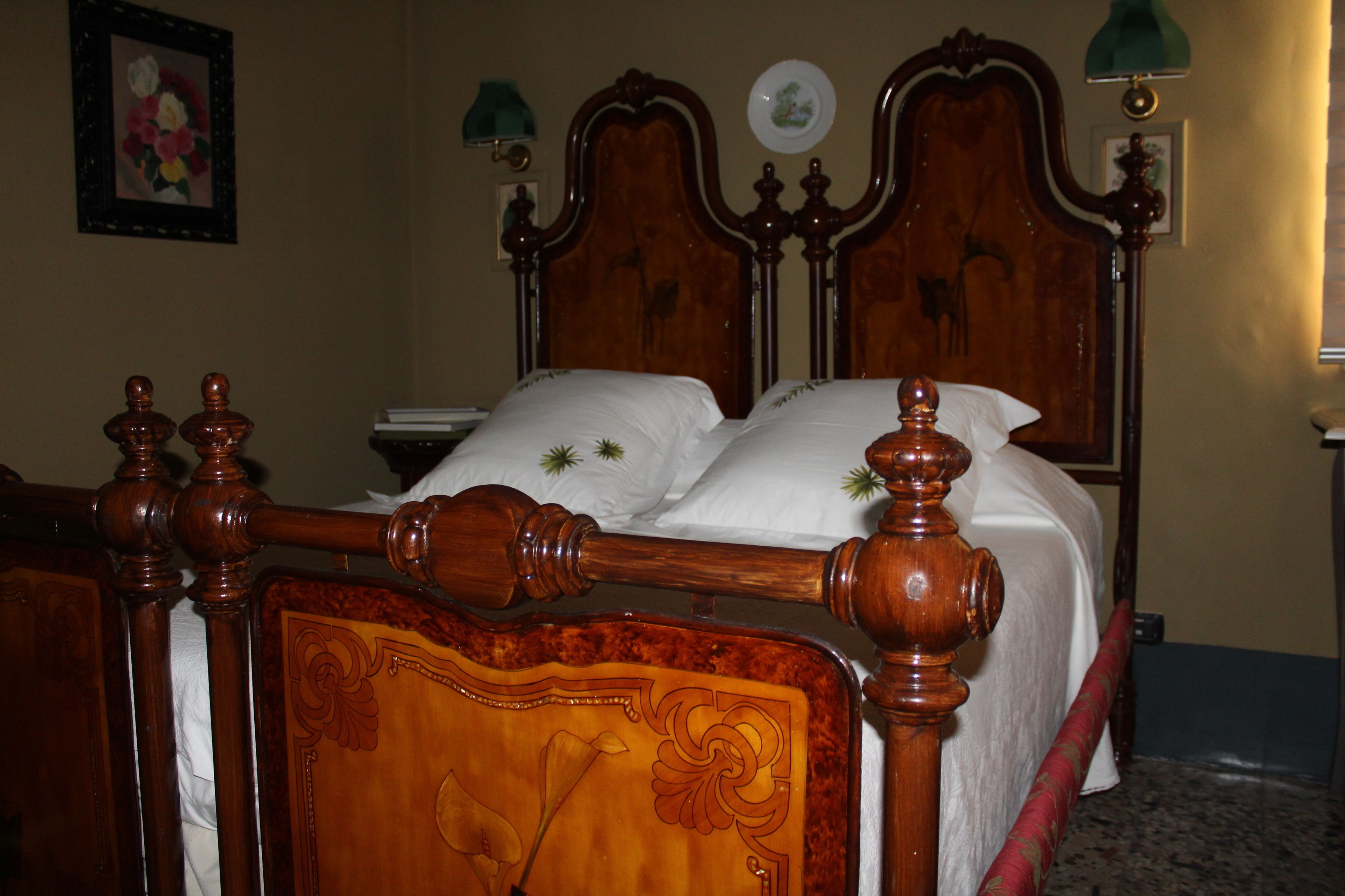 Una cama de madera con cabecera, una mesita de noche y una lámpara.