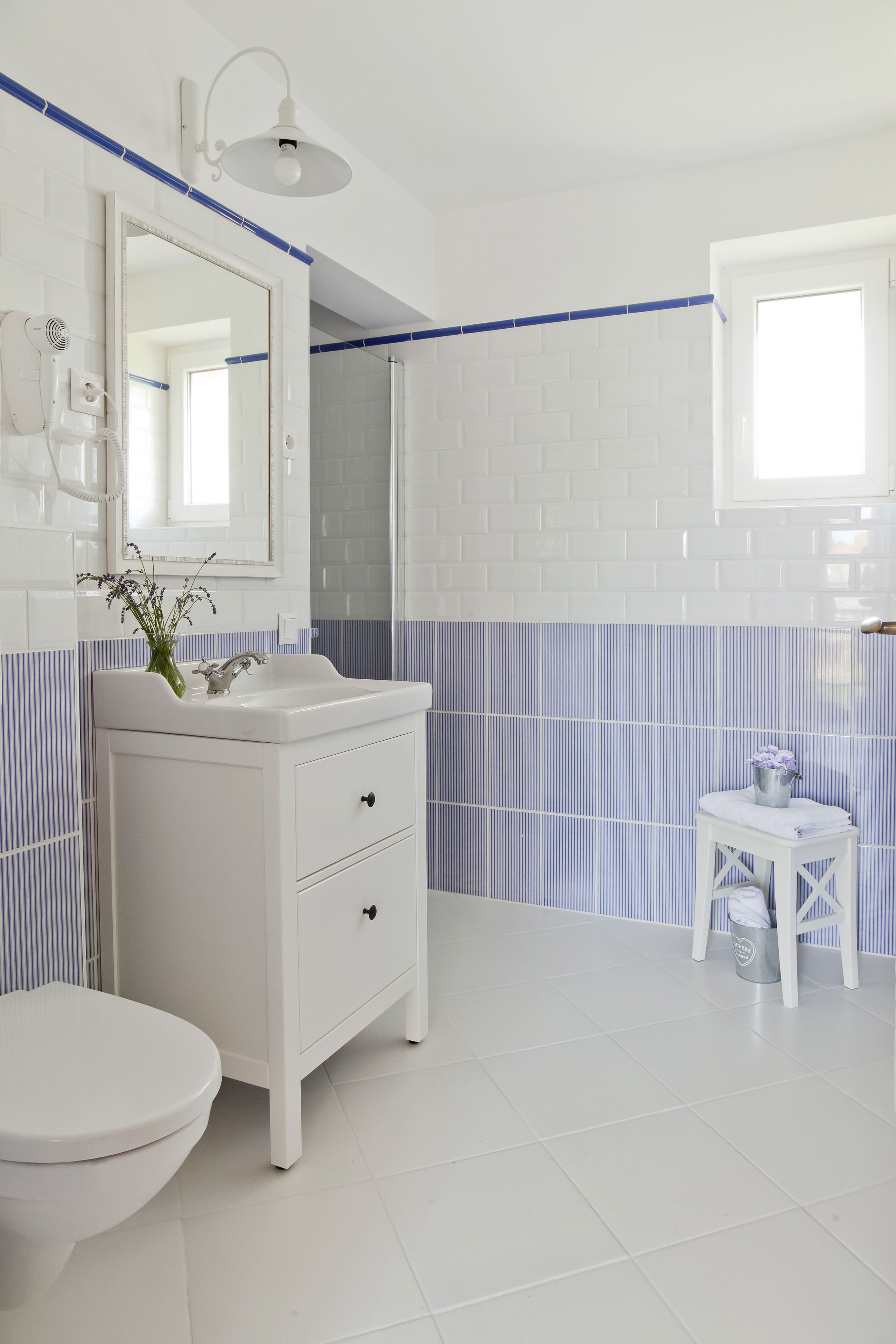 A bathroom with white fixtures, a mirror, a sink, and a toilet.