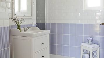 A bathroom with white fixtures, a mirror, a sink, and a toilet.
