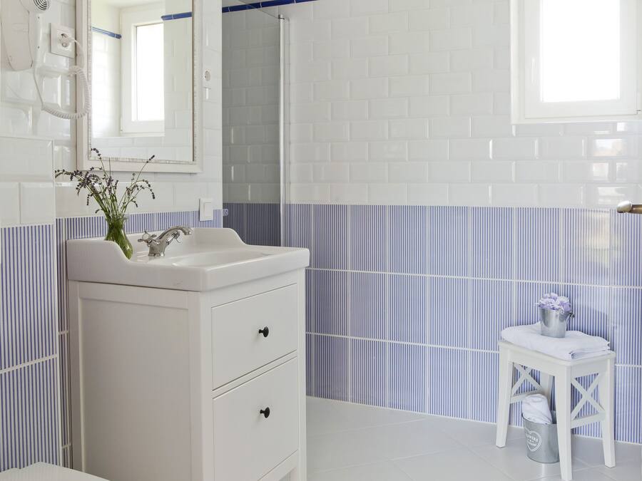 A bathroom with white fixtures, a mirror, a sink, and a toilet.