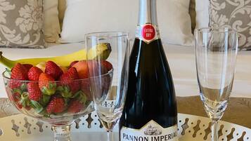 A bottle of Pannon Imperial wine, a bowl of strawberries, and two wine glasses on a tray.