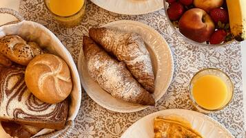 A breakfast table with various dishes including eggs, pastries, and fruits.