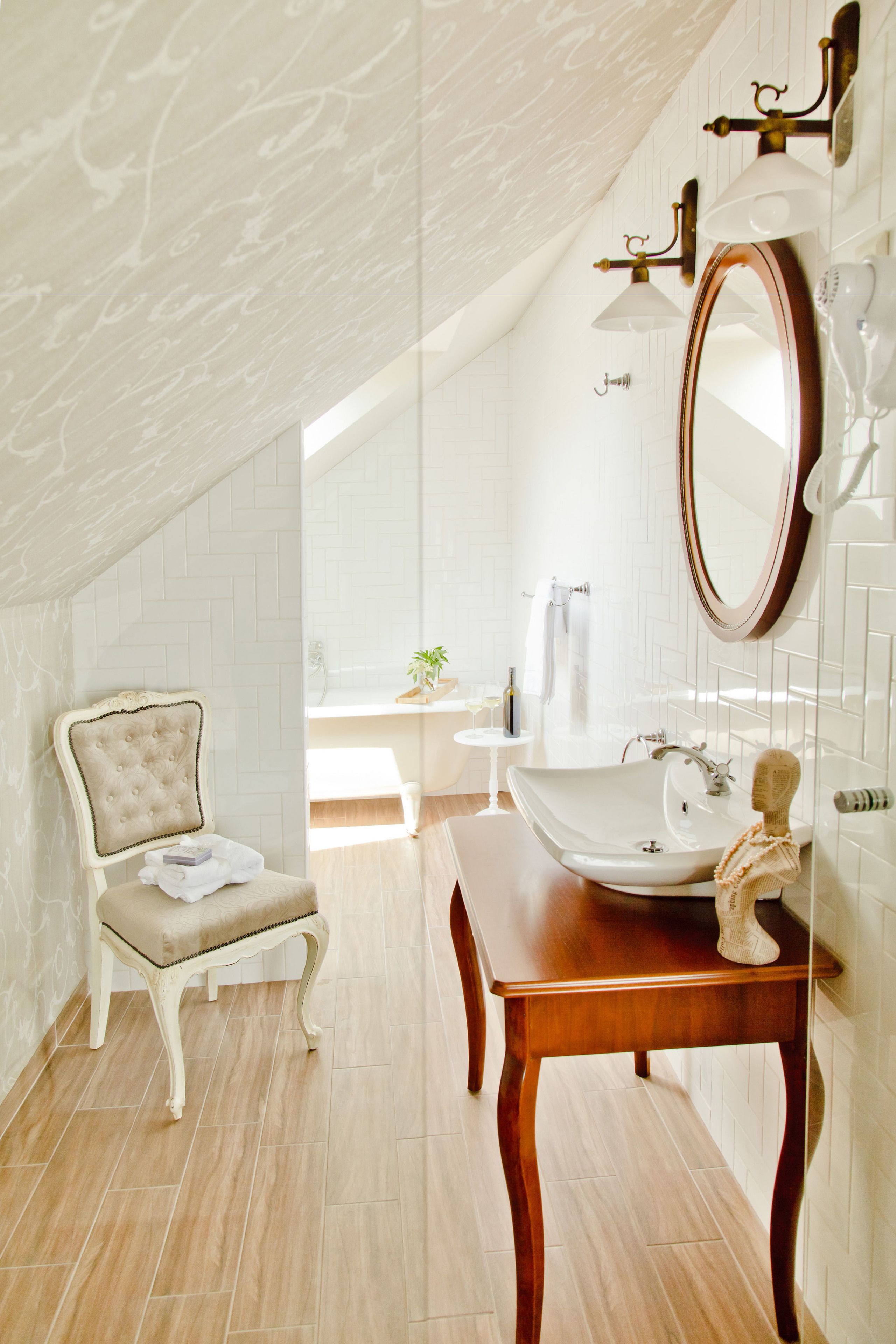 Un baño con tocador, un espejo grande y una silla.