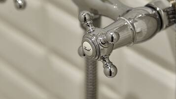 A close-up of a bathroom faucet with a flexible hose.