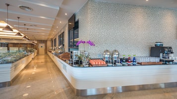 Eine moderne Hotelhalle mit einer Rezeption, einer Wand mit Muster und einer langen Theke mit Annehmlichkeiten.