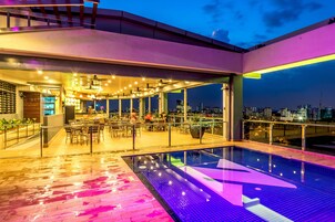 Una piscina al aire libre, sillones reclinables de piscina