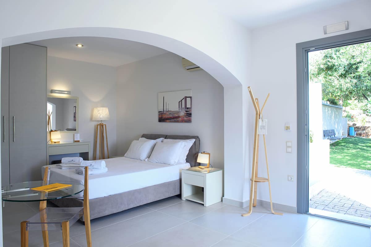 A modern bedroom with a bed, bedside table, lamp, and a glass table.