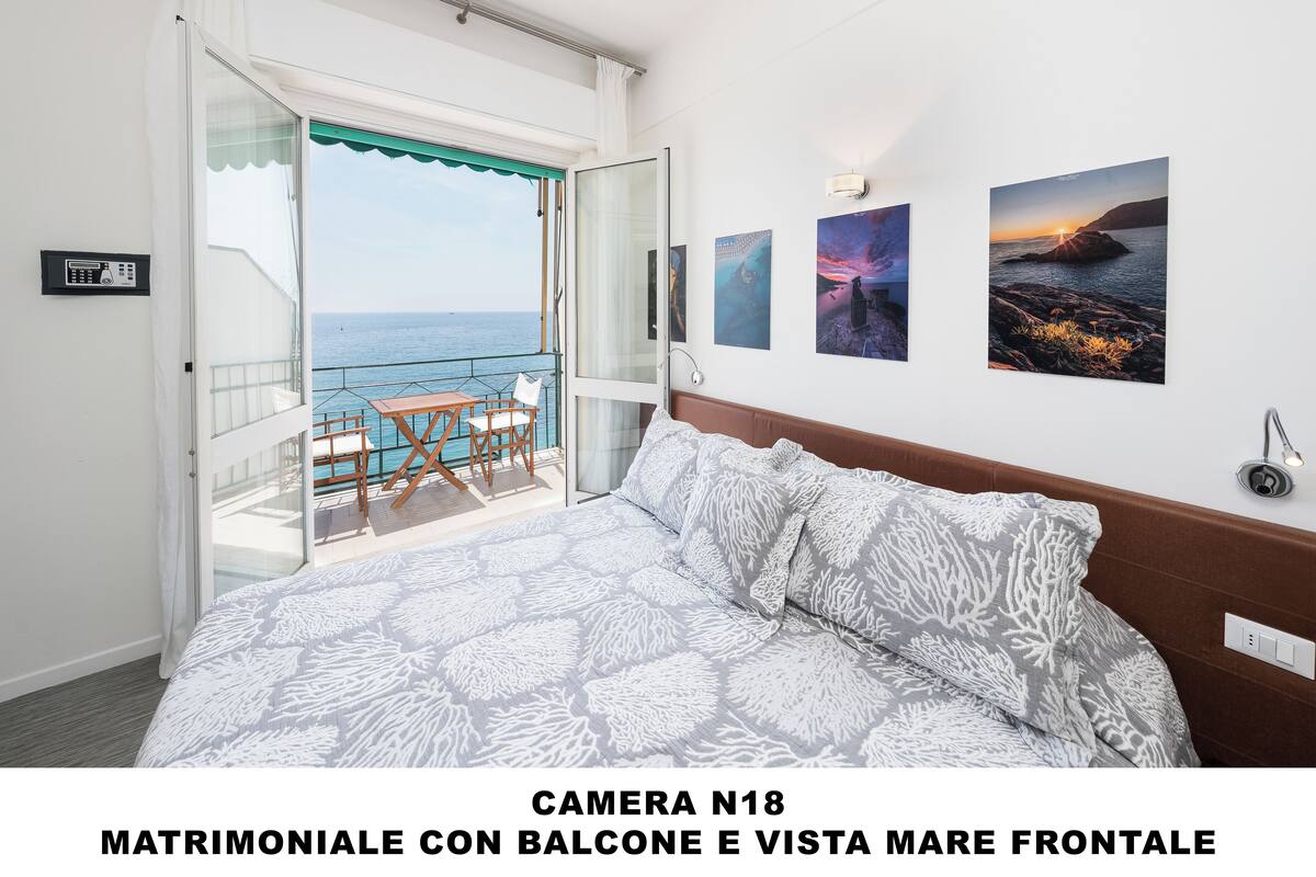 Habitación doble, balcón, vista al mar | Caja de seguridad en la habitación, escritorio y ropa de cama