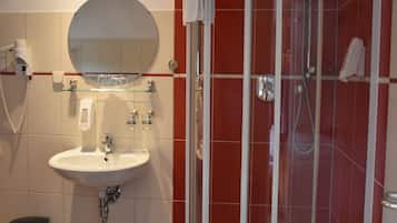Un baño con lavamanos, espejo y ducha.