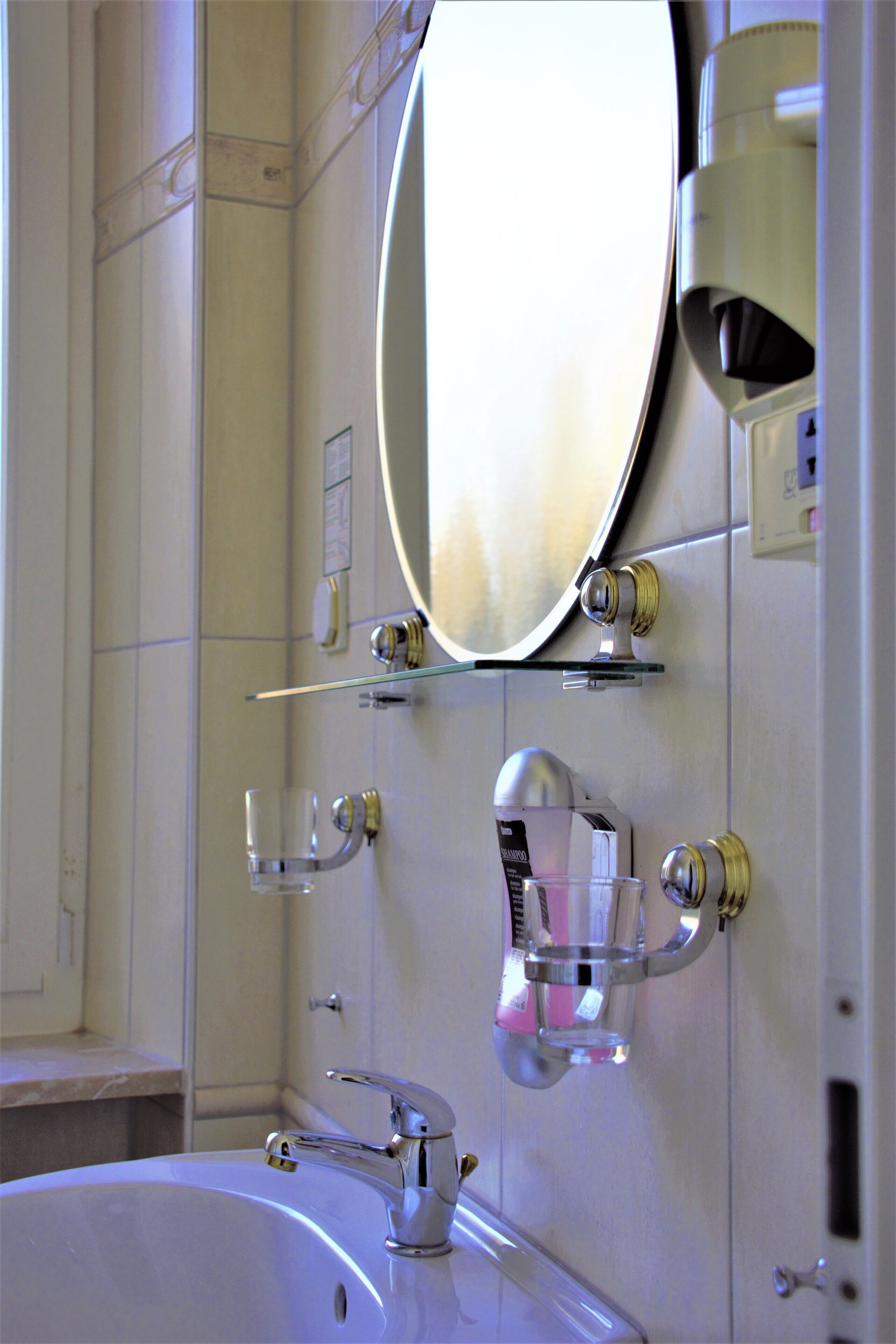 A bathroom with a white sink, a mirror, and a glass shower enclosure.