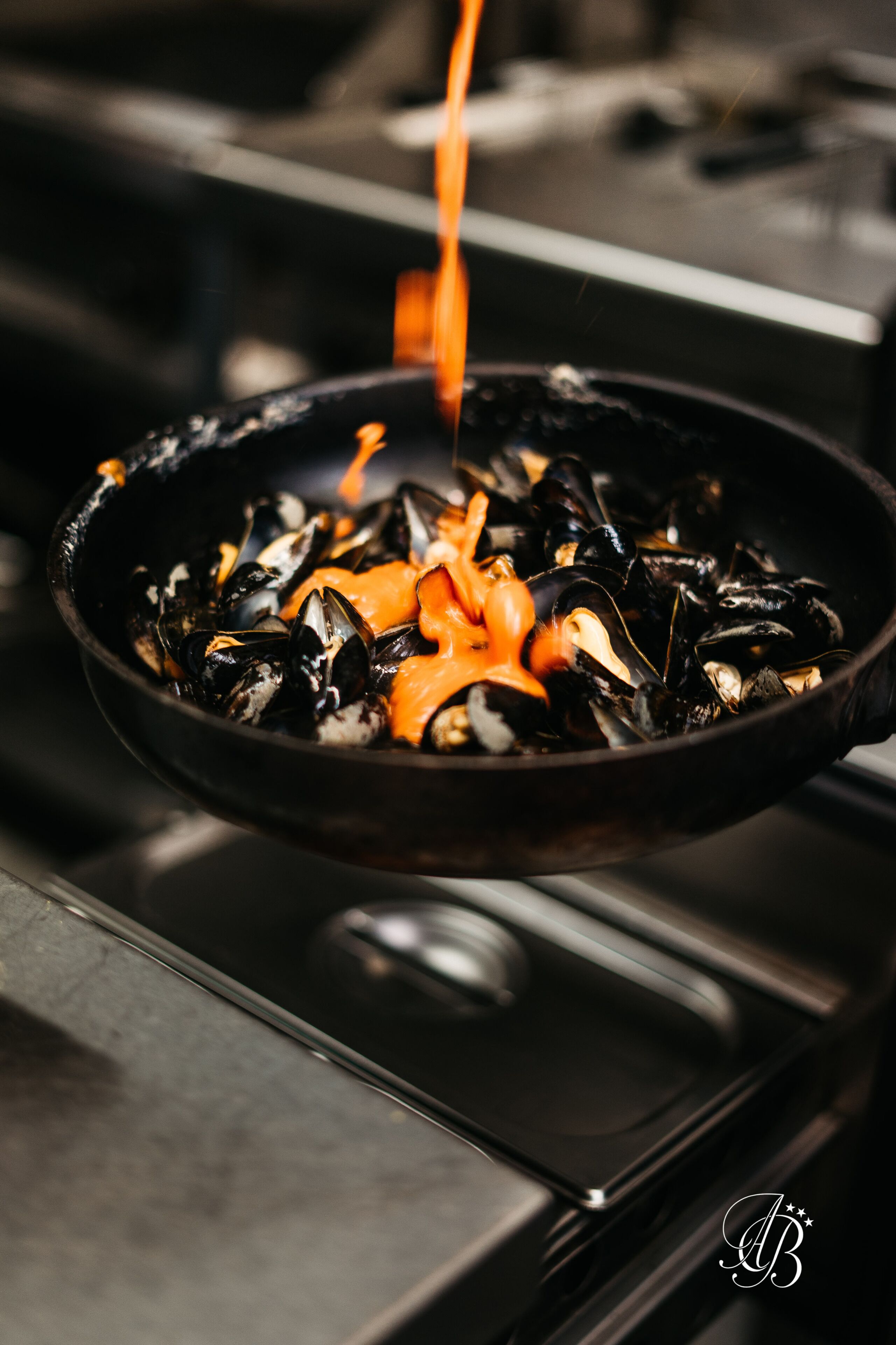 A pan of mussels being cooked on a stove.