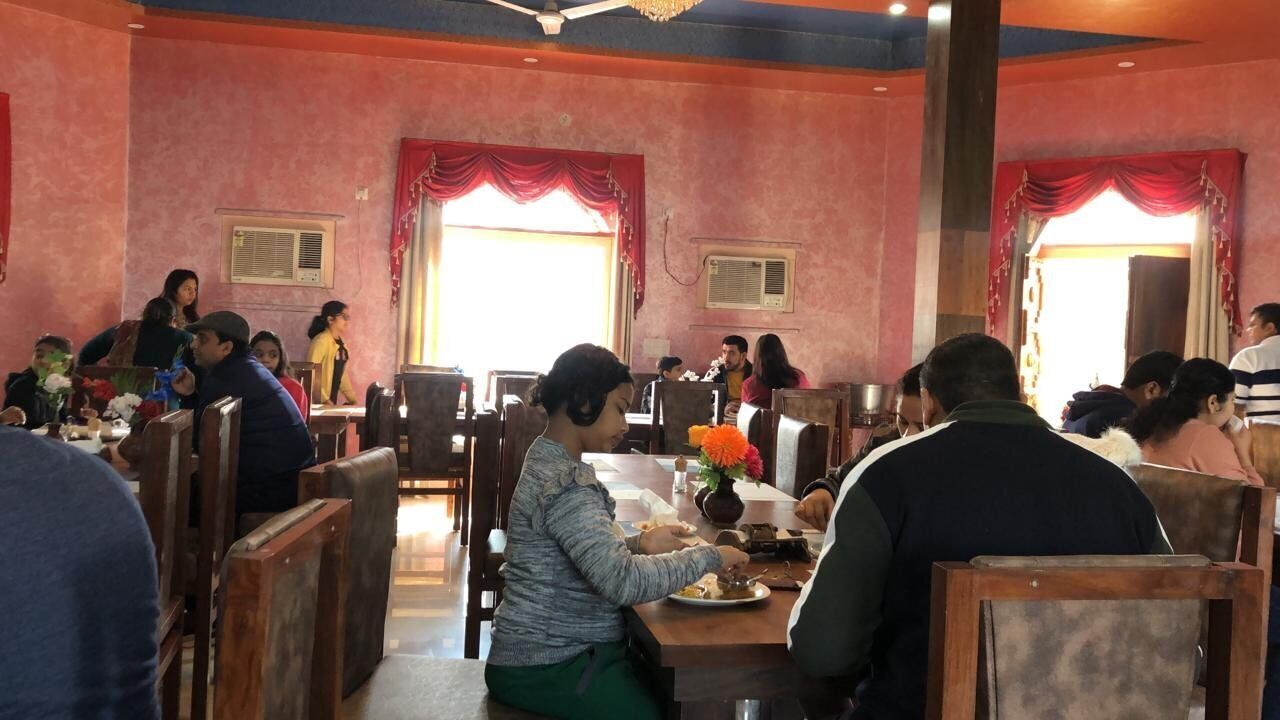 A restaurant with wooden furniture and red curtains.