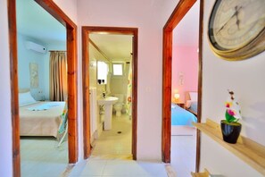 A hotel corridor with a bed, bathroom, and a clock on the wall. - Eliana (Kissamos)