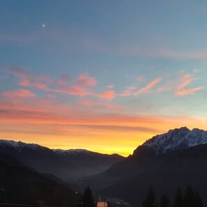 A mountainous landscape with a sunset and a crescent moon. - Albergo Sargas (Cevo)