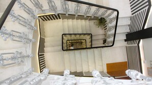 Una escalera moderna con un diseño único, que presenta una columna central y elementos decorativos a los lados.