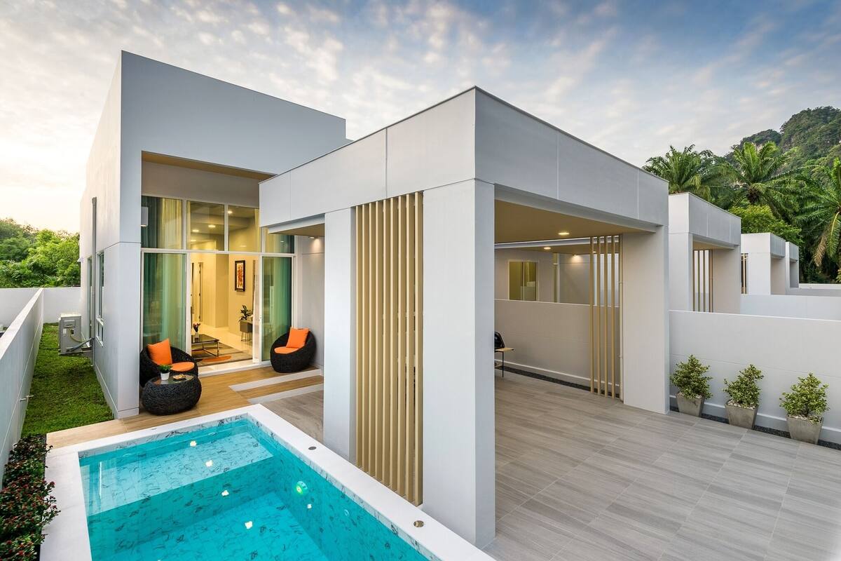 A modern house with a pool, large windows, and outdoor seating.