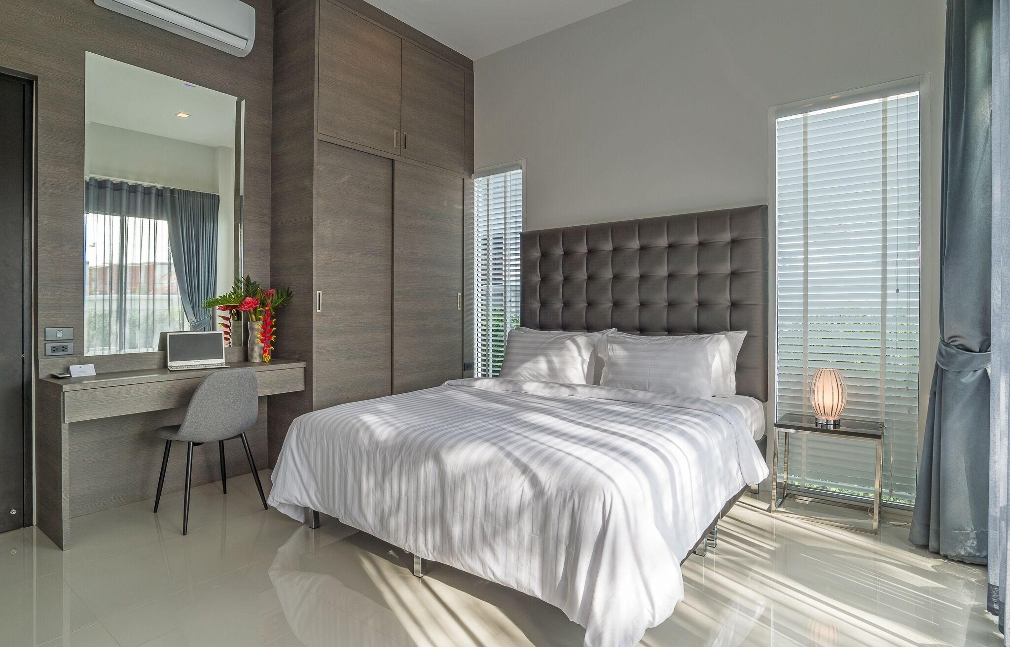 Un dormitorio moderno con una cama grande, un escritorio y una silla.