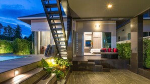 A modern house with a pool, a staircase, and a well-lit interior. - The Haven Krabi (Krabi)