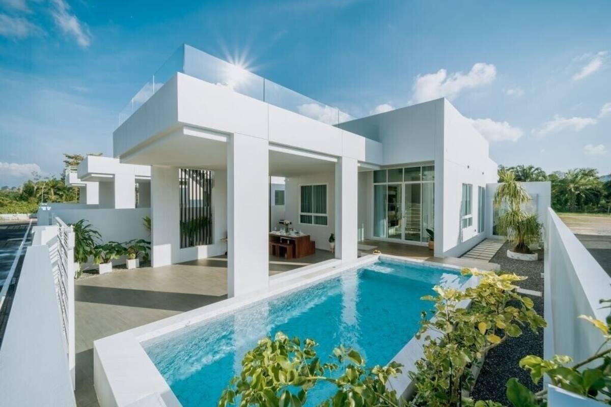 A modern house with a swimming pool, large windows, and a flat roof.