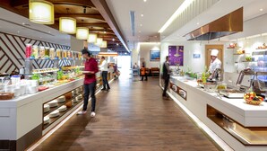 Un espace buffet moderne, doté de différents postes de service et d’un sol en bois.