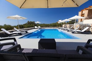 Piscine extérieure, parasols de plage, chaises longues