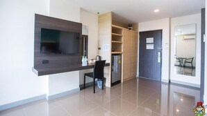 Una cocina moderna con televisión integrada, refrigerador y comedor con mesa y sillas.