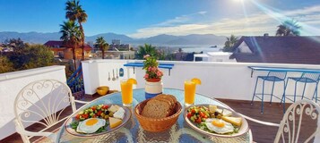 A dining table with breakfast items and a view of mountains.