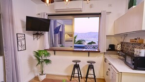 Ein kompakter Wohnbereich mit Küche, Essbereich und einem Fenster mit Blick.