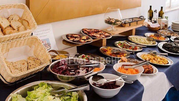 A buffet table with various dishes and a wine glass. - Hotel Villa Pozzi (Cattolica)