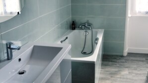 A modern bathroom with a bathtub, a sink, and a mirror. - Château des Noces (Bazoges-en-Pareds)