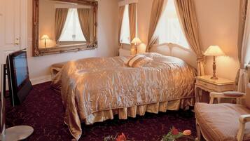 Una habitación de hotel con una cama grande, un escritorio, una silla y un espejo.
