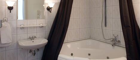 A bathroom with a bathtub, a sink, and a shower.