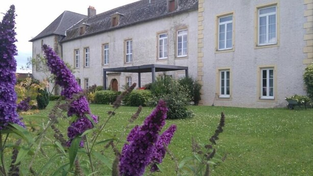 Un edifici gran de dues plantes amb un porxo cobert a la façana.