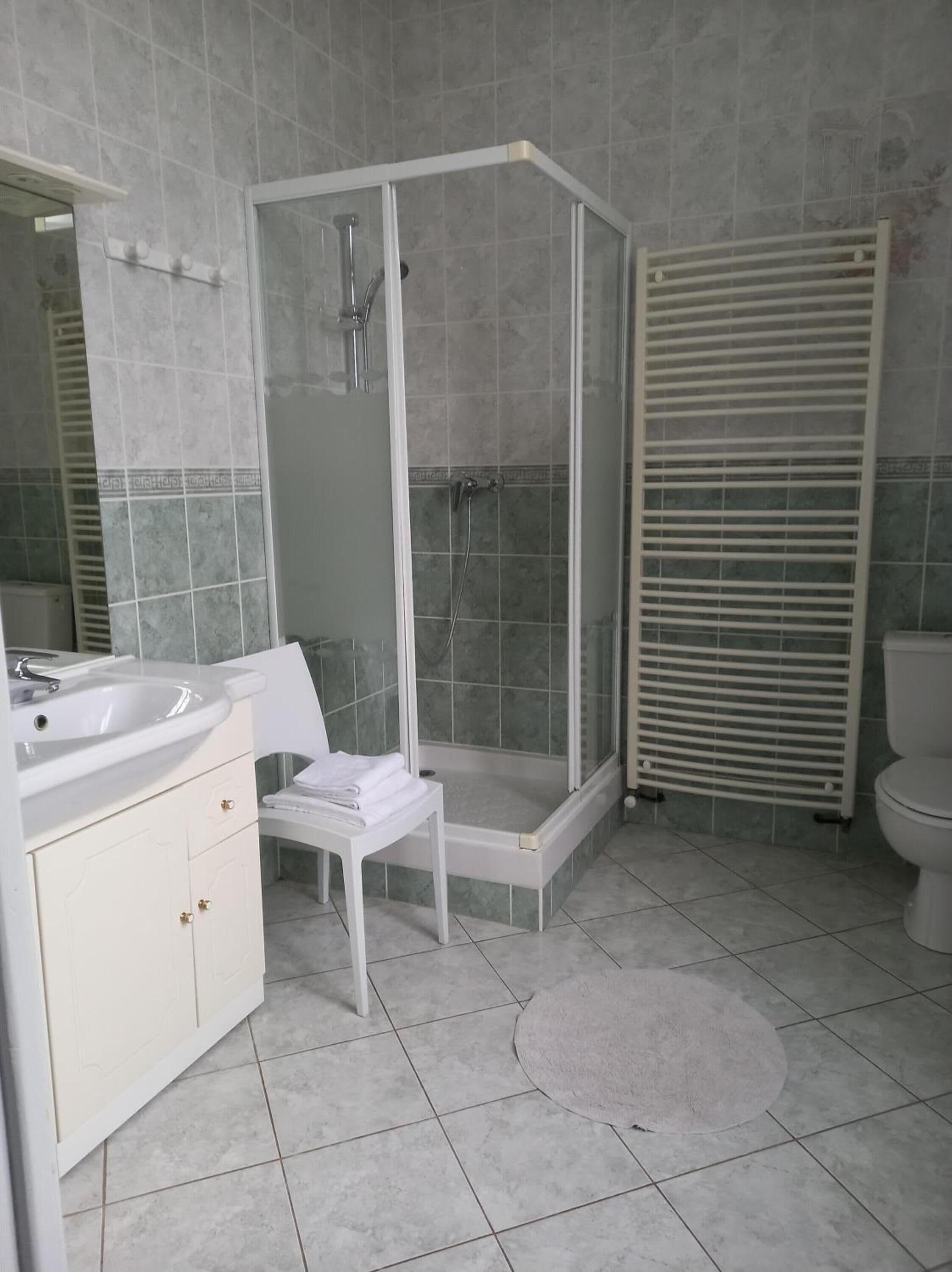 Une salle de bain moderne avec une douche à parois de verre, un lavabo blanc et des toilettes.