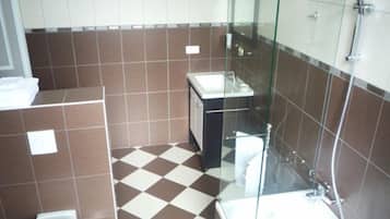 A bathroom with a glass-enclosed shower, a sink, and a toilet.