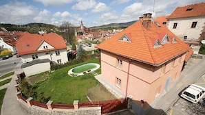 A residential area with a building featuring a red-tiled roof, a swimming pool, and a stone wall surrounding the property. - Pension Gardena Kaplická 21 (Cesky Krumlov)