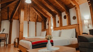 Ein Zimmer in einer Holzhütte mit einem Bett, einem Schreibtisch und einem Stuhl.