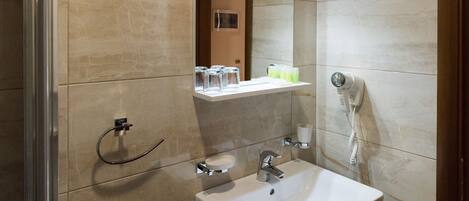 A modern bathroom with a sink, mirror, and towel rack.