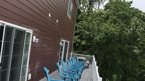 A wooden deck with blue chairs and a white railing. - 140 S. Monroe St., Watkins Glen (Watkins Glen)