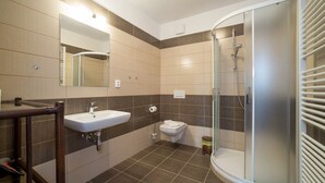 A modern bathroom with a glass-enclosed shower, a sink, and a toilet. - Villa Gardena (Cesky Krumlov)