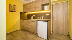 A compact kitchen with wooden cabinets, a built-in oven, and a small refrigerator. - Villa Gardena (Cesky Krumlov)
