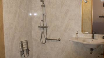 Un baño moderno con ducha, lavabo e inodoro.