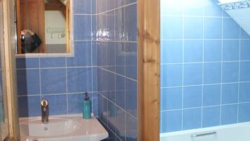 Une salle de bain avec un lavabo, un miroir et une baignoire.
