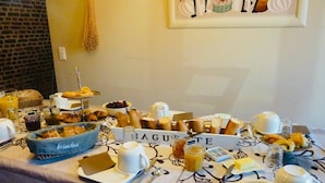 Een ontbijtbuffet met croissants, gebakjes en een bord waarop 